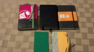 Clockwise from Upper Left: Evernote Moleskine, Pen and Ink, Moleskine Lined, Moleskine Extra-Small in yellow, Moleskine Volant Notebook Extra-Small