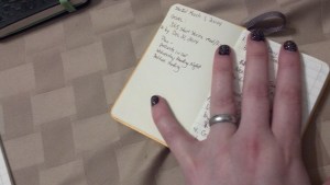 The Extra-Small notebook with writing. This is my short story ranking book. The glow-in the dark skulls on the cover were the extra nail wraps from doing my nails at Rainforest. I thought they looked too cool to just toss out.