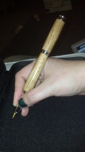 pen in hand with cap on back.